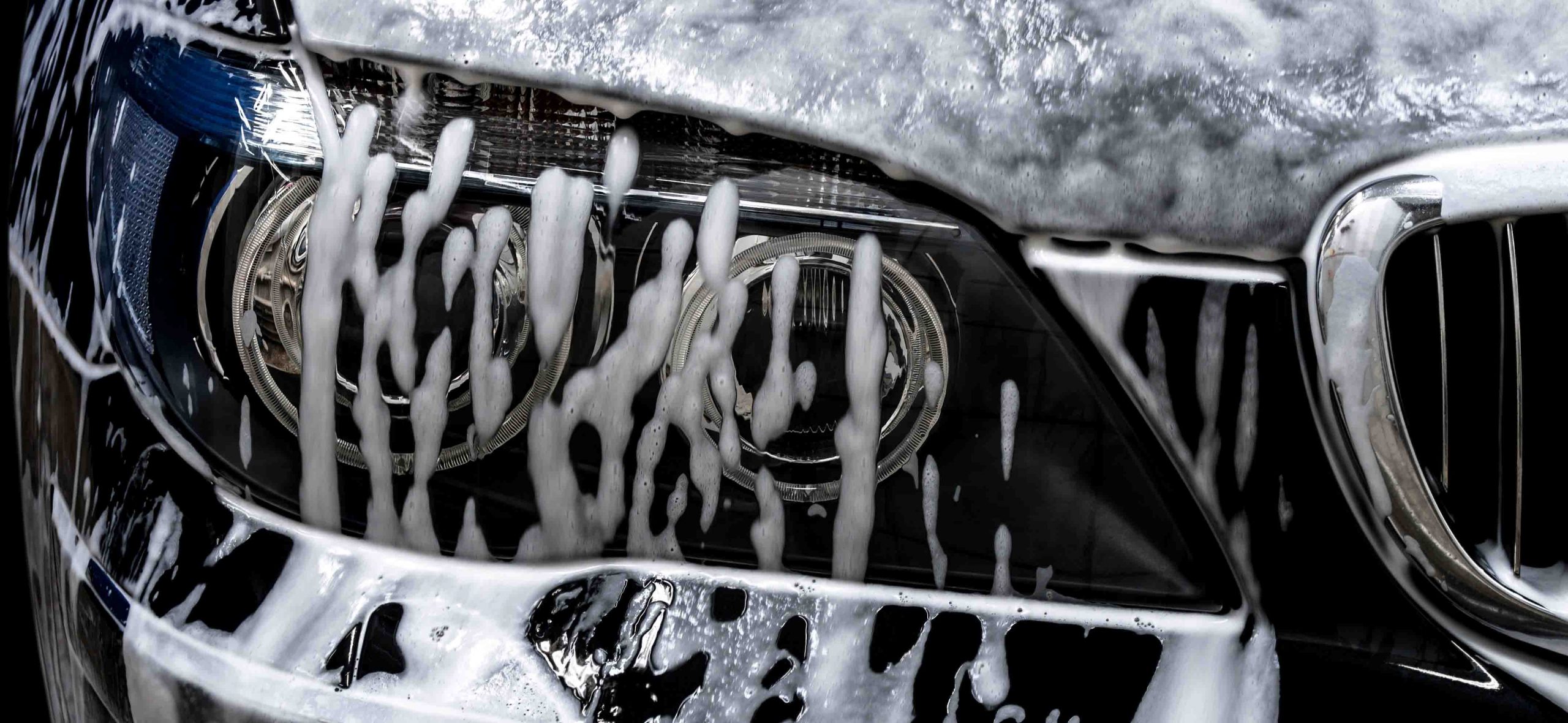 Fotografija prikazuje ročno zunanje čiščenje avtomobila, ki zajema tudi čiščenje s peno in zaščito podvozja.